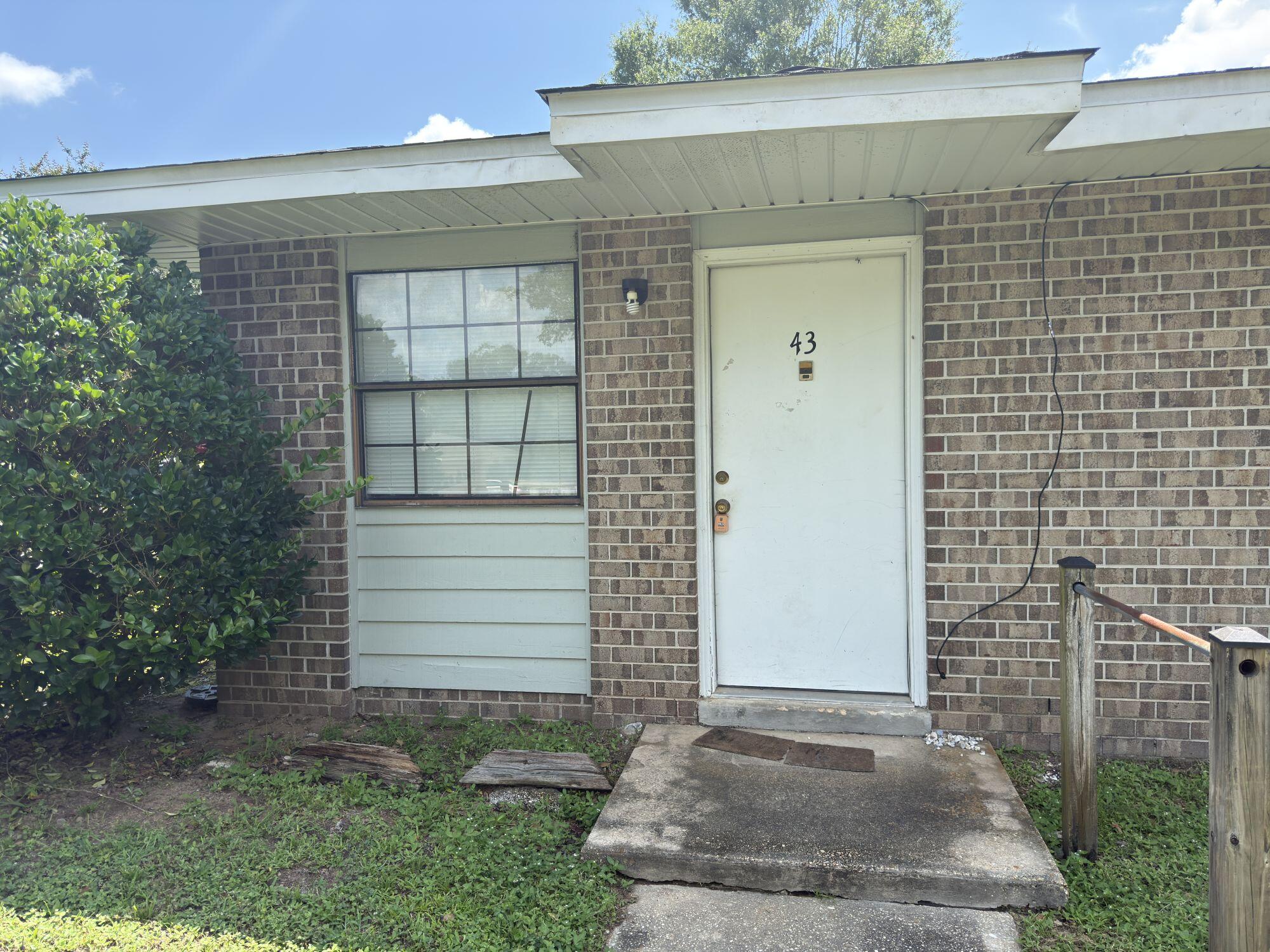 4260 Highway 90, Unit 43 Pace, FL 32571 - Photo 1 of 6 a front view of a house with a yard