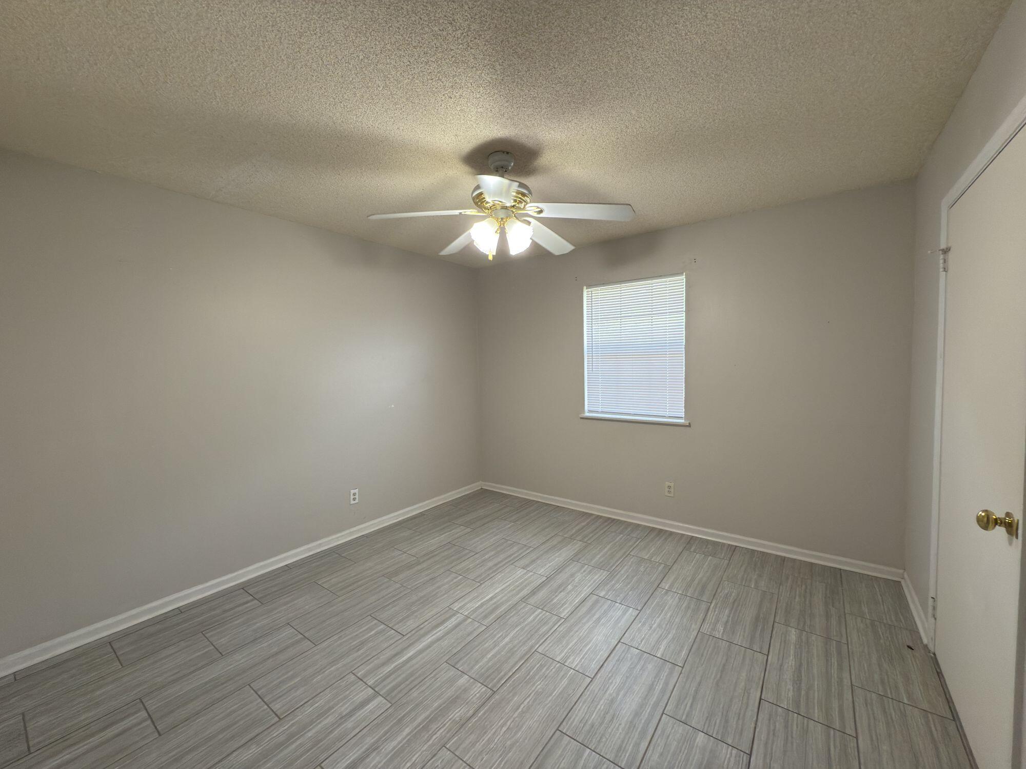 4260 Highway 90, Unit 43 Pace, FL 32571 - Photo 6 of 6 a view of a room with wooden floor and a ceiling fan