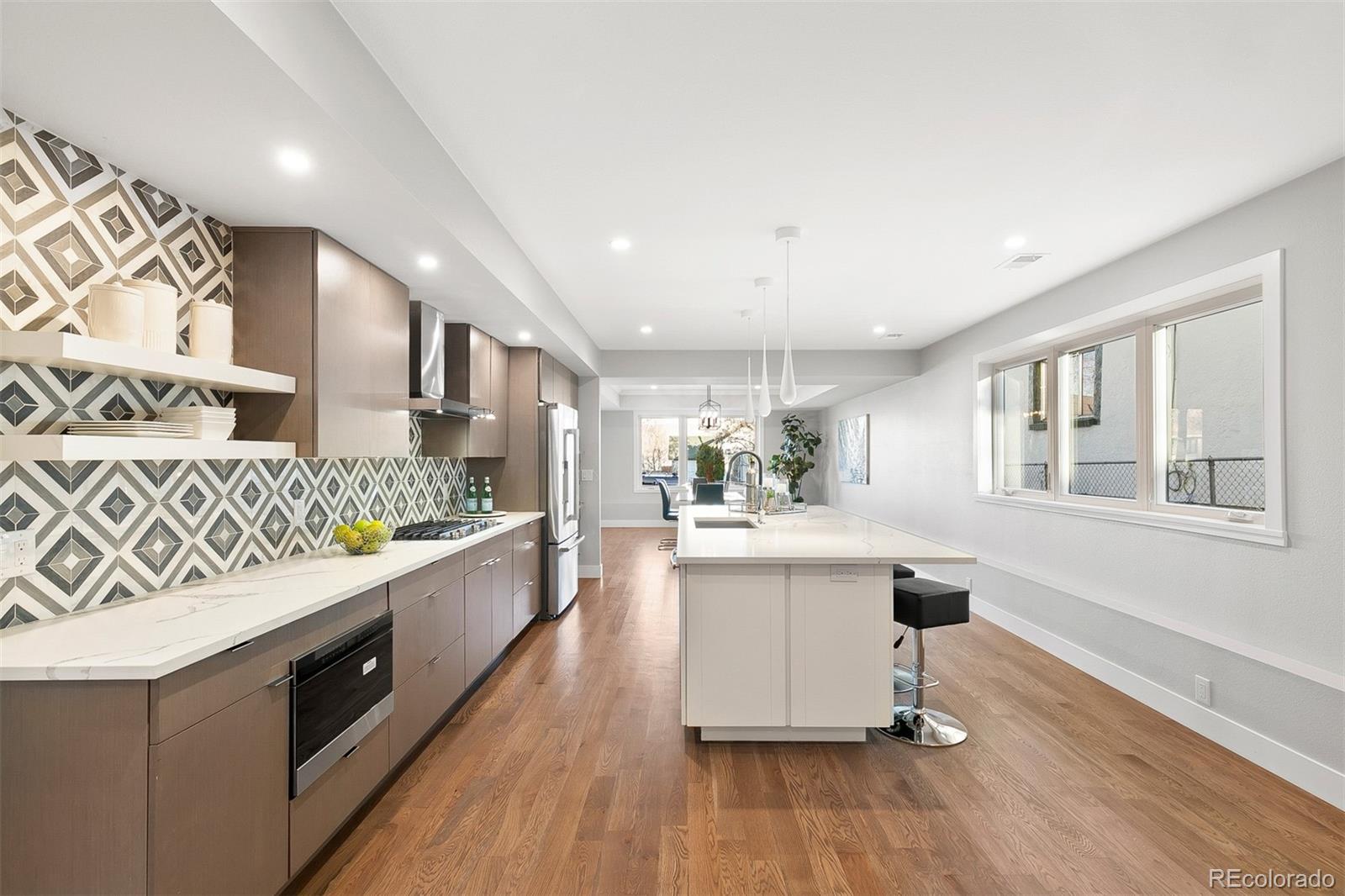 3935 Jason Street Denver, CO 80211 - Photo 3 of 34 a large white kitchen with stainless steel appliances granite countertop a stove and a wooden floors
