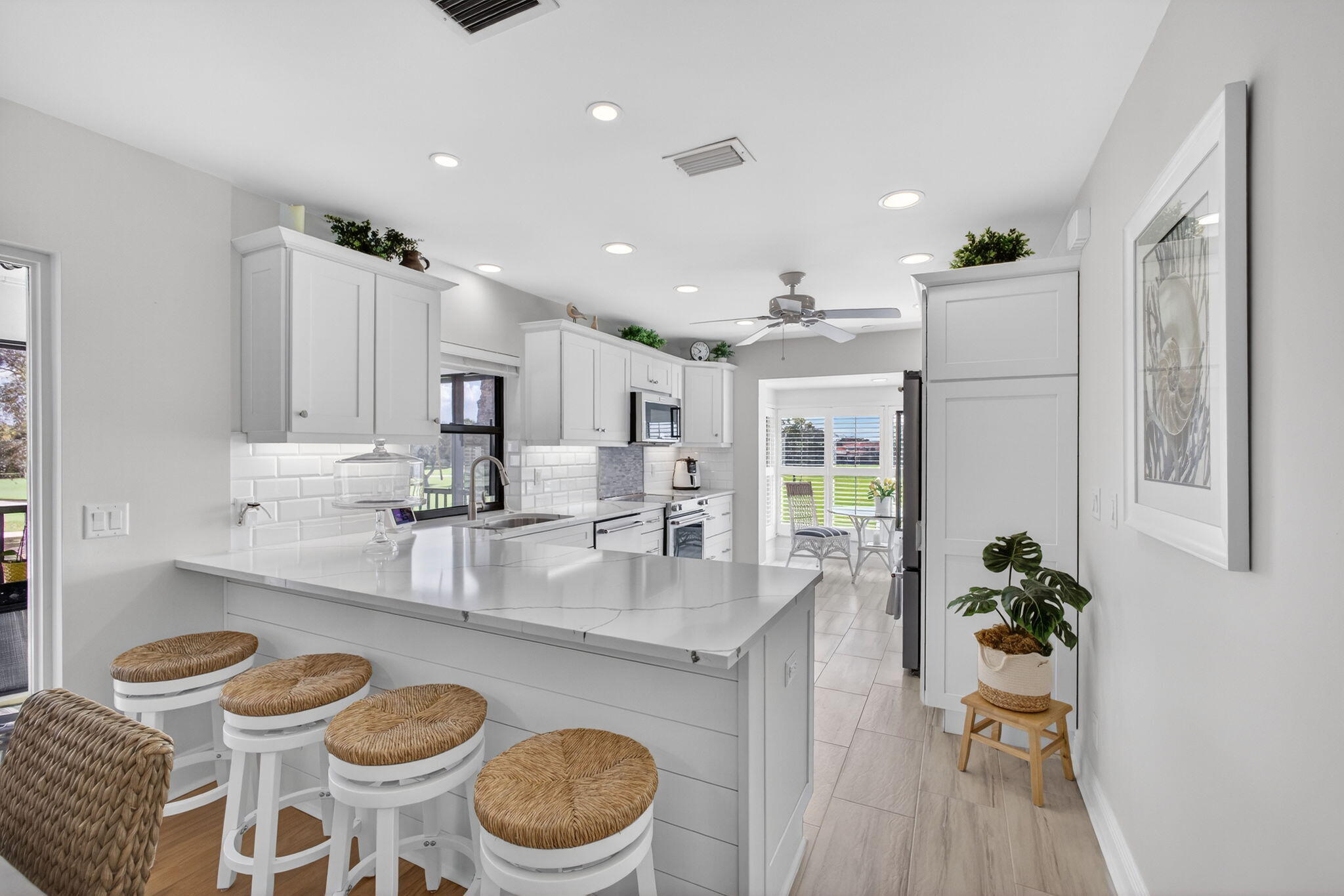 16550 Traders Crossing South, Unit 248 Jupiter, FL 33477 - Photo 12 of 50 a very nice looking open dining room with kitchen island furniture a refrigerator and a sink