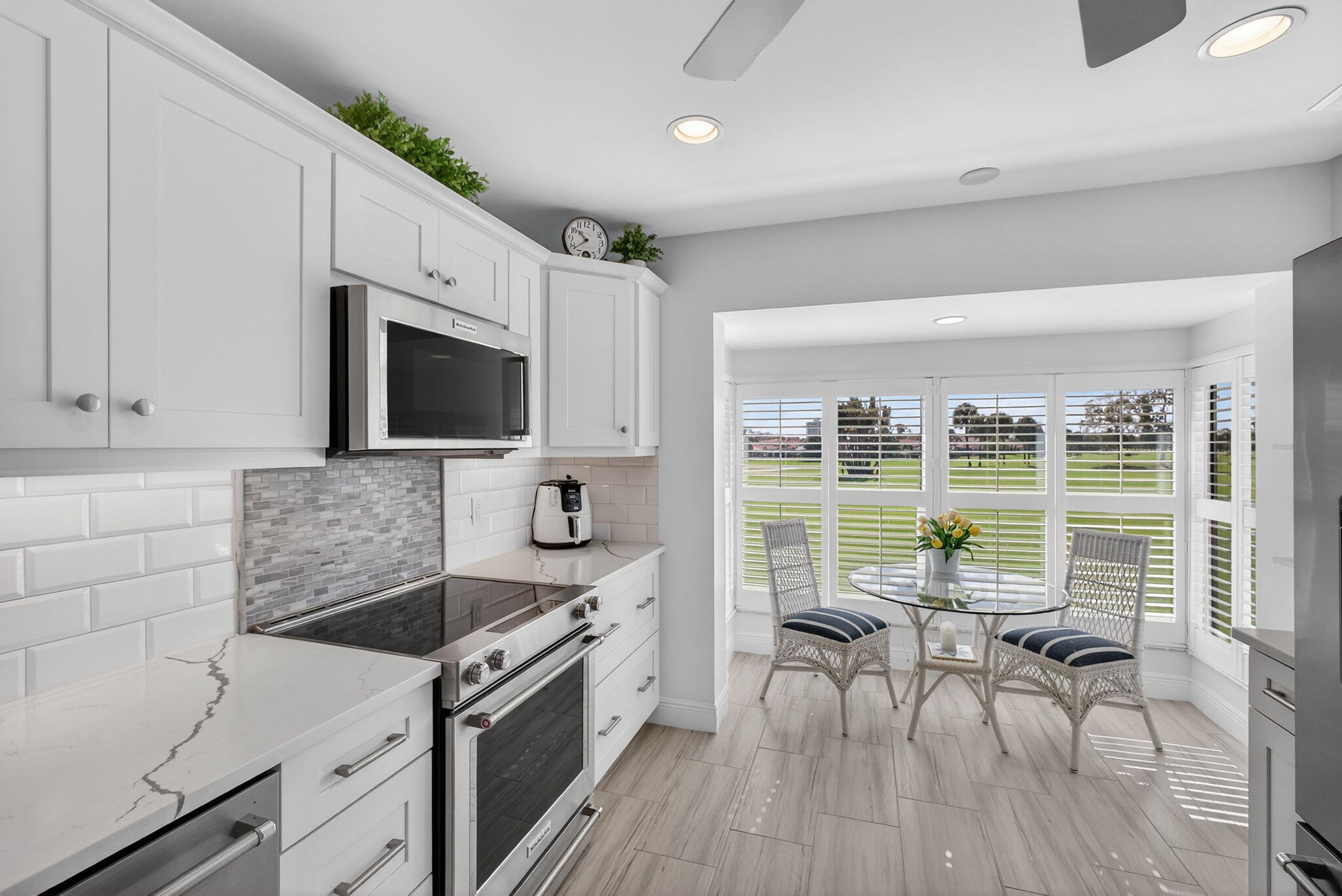 16550 Traders Crossing South, Unit 248 Jupiter, FL 33477 - Photo 14 of 50 a kitchen with granite countertop a stove a sink a dining table and chairs