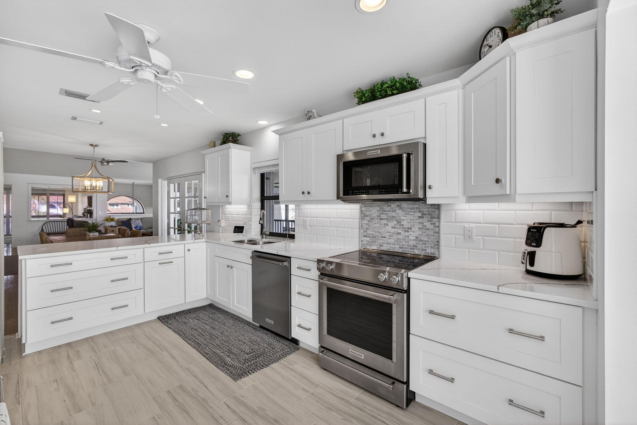 16550 Traders Crossing South, Unit 248 Jupiter, FL 33477 - Photo 18 of 50 a kitchen with white cabinets stainless steel appliances and sink