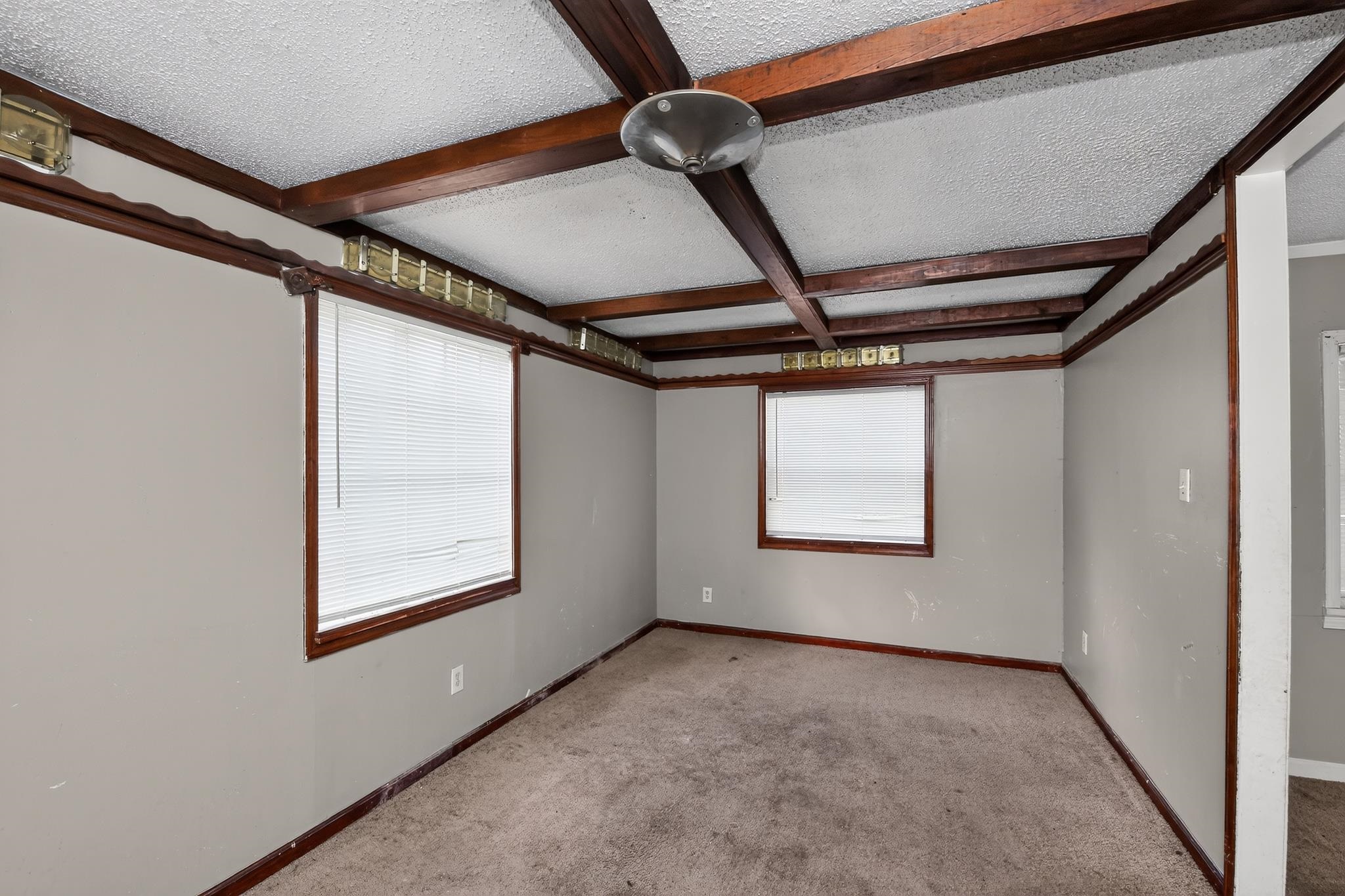 3791 Windermere Road Memphis, TN 38128 - Photo 6 of 18 Room featuring exposed ceiling beams, two windows with blinds, wall-mounted lighting accents, and a ceiling light fixture