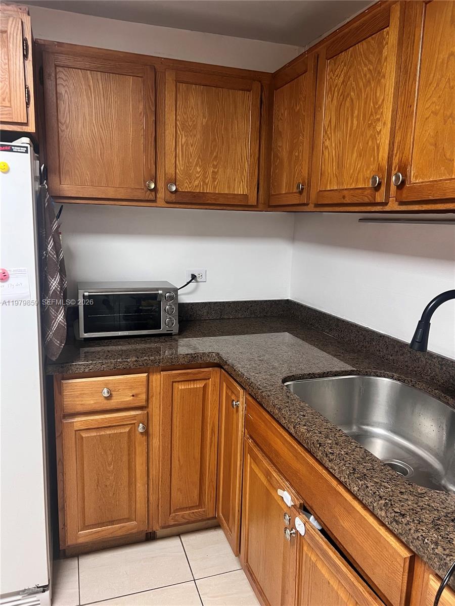 3680 Inverrary Drive, Unit 1T Lauderhill, FL 33319 - Photo 11 of 14 a kitchen with granite countertop stainless steel appliances a sink and cabinets