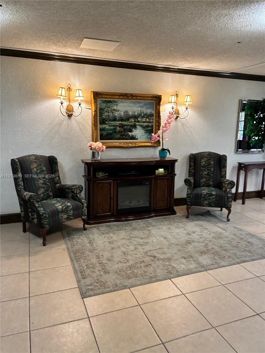 3680 Inverrary Drive, Unit 1T Lauderhill, FL 33319 - Photo 2 of 14 a living room with furniture a flat screen tv and a fireplace