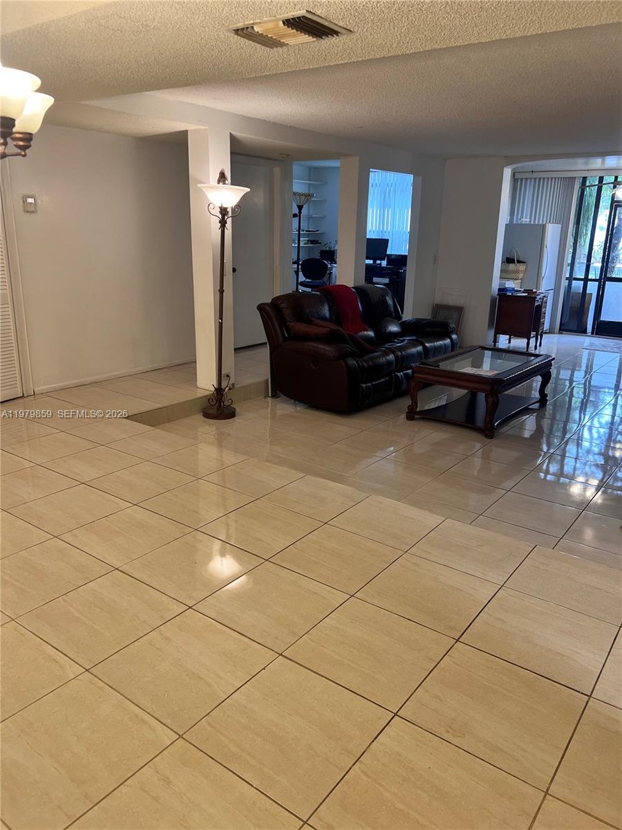 3680 Inverrary Drive, Unit 1T Lauderhill, FL 33319 - Photo 6 of 14 a living room with furniture and a dining table