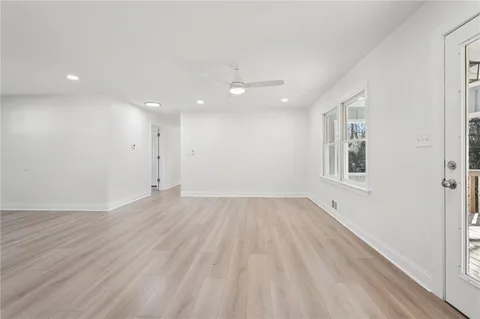 a view of a hallway with wooden floor and windows