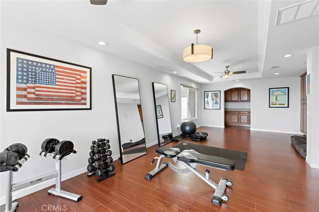 a room with gym equipment and wooden floor