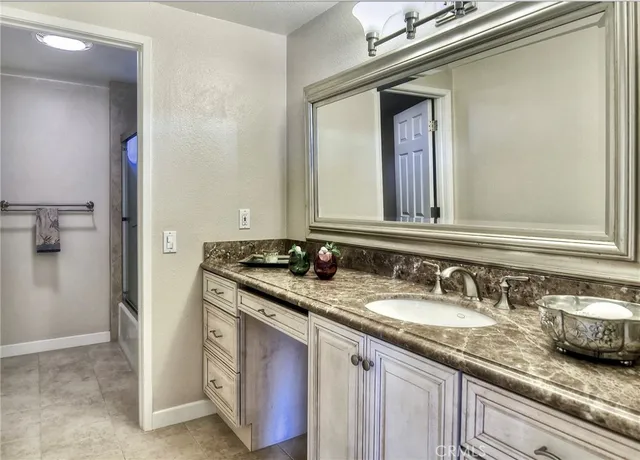 a bathroom with a granite countertop sink and a mirror