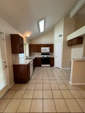 a large kitchen with a stove a refrigerator and a oven