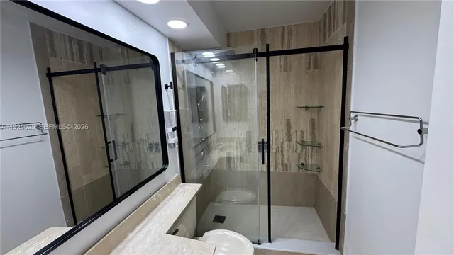 a bathroom with a glass shower door and a sink