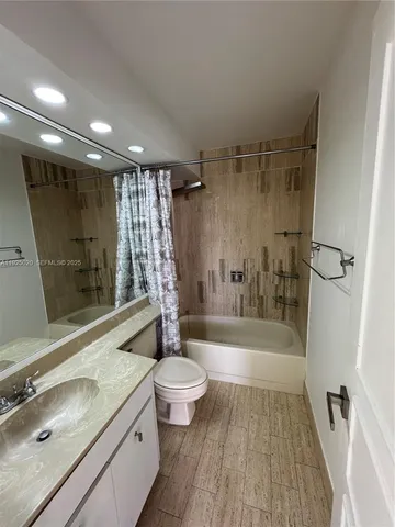 a bathroom with a sink a toilet a mirror and shower