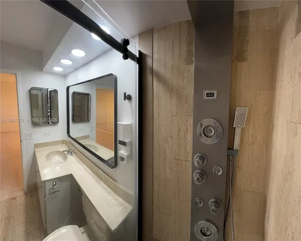a bathroom with a shower sink and mirror
