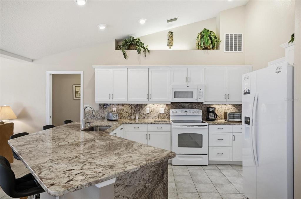 2 Cher Court Palm Coast, FL 32137 - Photo 17 of 64 a kitchen with a stove a sink a refrigerator and cabinets