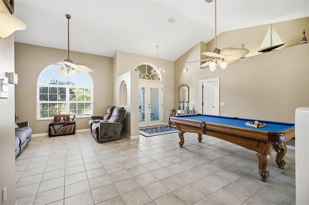 2 Cher Court Palm Coast, FL 32137 - Photo 9 of 64 a living room with patio furniture and a chandelier