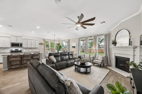 a living room with furniture a flat screen tv and a large window