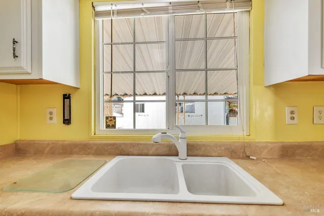 a bathroom with a granite countertop sink and a window