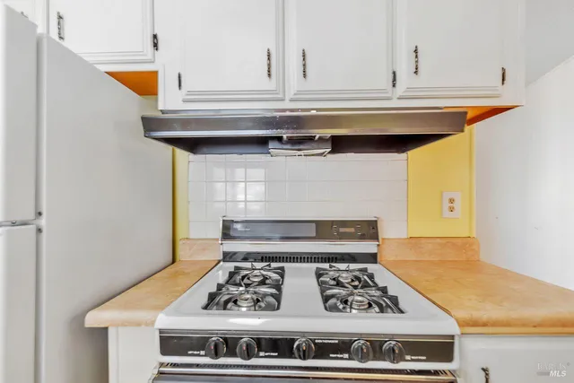 a stove top oven sitting inside of a kitchen