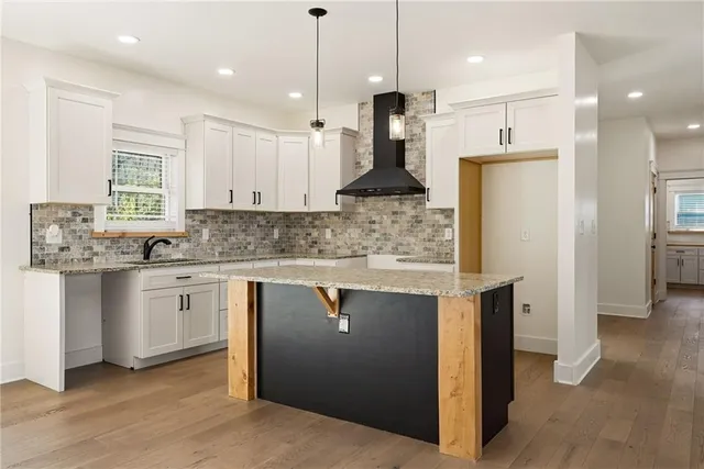 a kitchen with stainless steel appliances granite countertop a sink a refrigerator and a stove