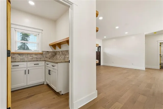 a kitchen with granite countertop white cabinets and white appliances