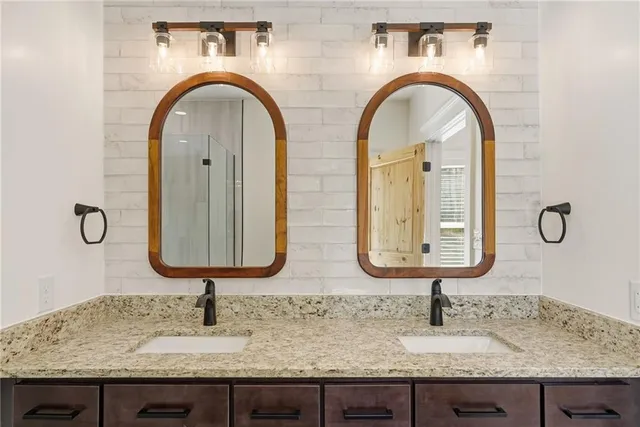 a bathroom with double vanity sinks and two mirrors