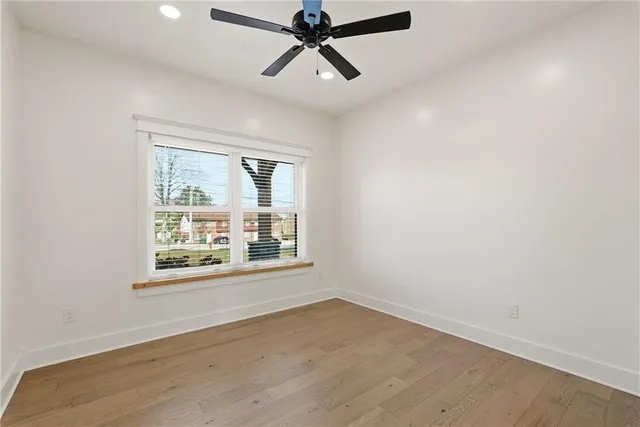 an empty room with a window and a ceiling fan
