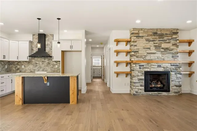 a view of kitchen with granite countertop cabinets and fireplace
