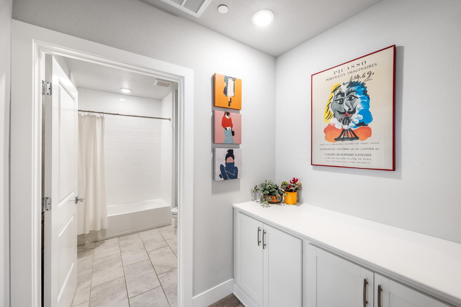 1661 Spring Street, Unit 433 Davis, CA 95616 - Photo 34 of 56 a hallway with painting on the wall and a shower