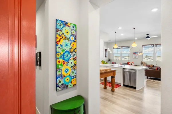 a kitchen with stainless steel appliances a stove a sink a refrigerator white cabinets and wooden floor