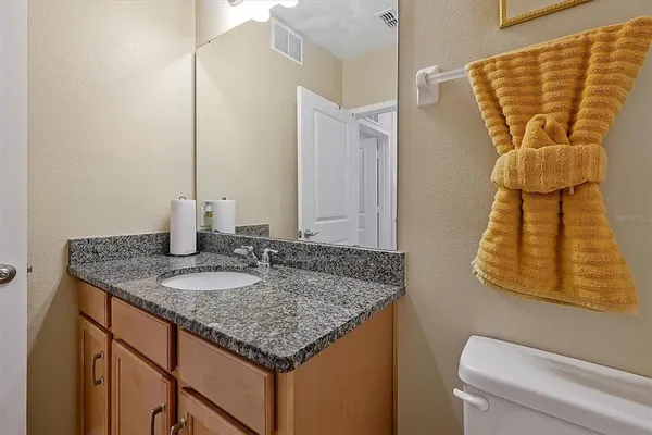 a bathroom with a granite countertop sink and a mirror