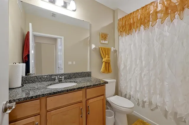 a bathroom with a granite countertop sink and a mirror