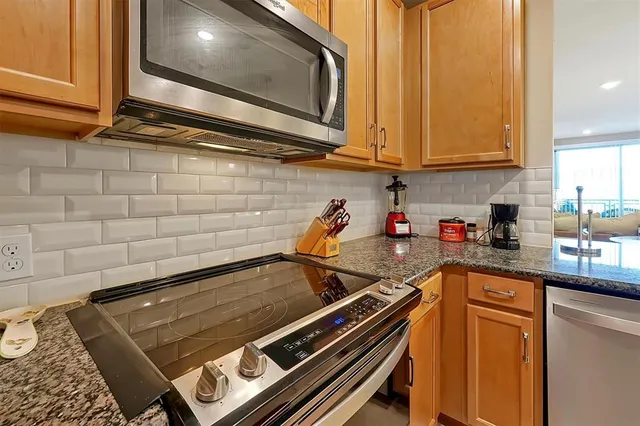 a kitchen with stainless steel appliances granite countertop a stove and a microwave