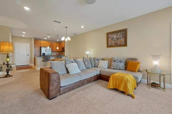 a living room with furniture and a view of kitchen