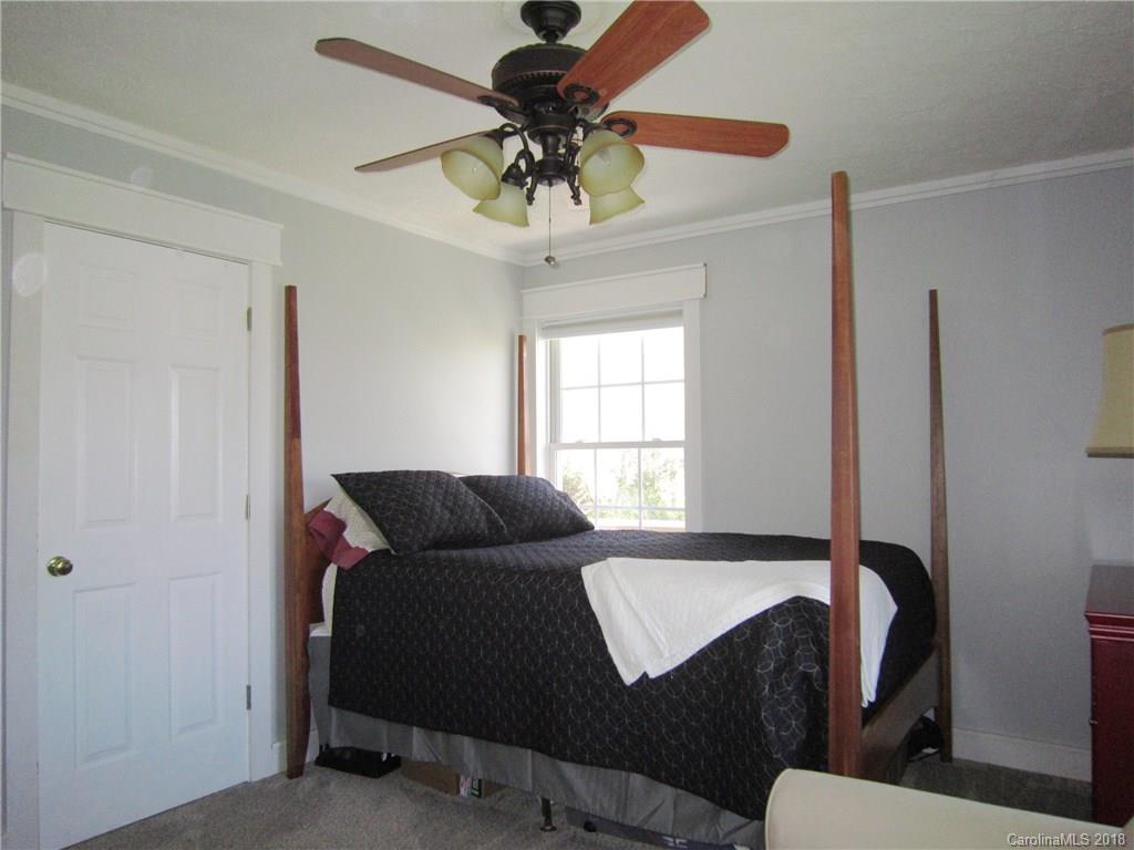 266 Murray Road Canton, NC 28716 - Photo 16 of 36 a bedroom with a bed and a chandelier