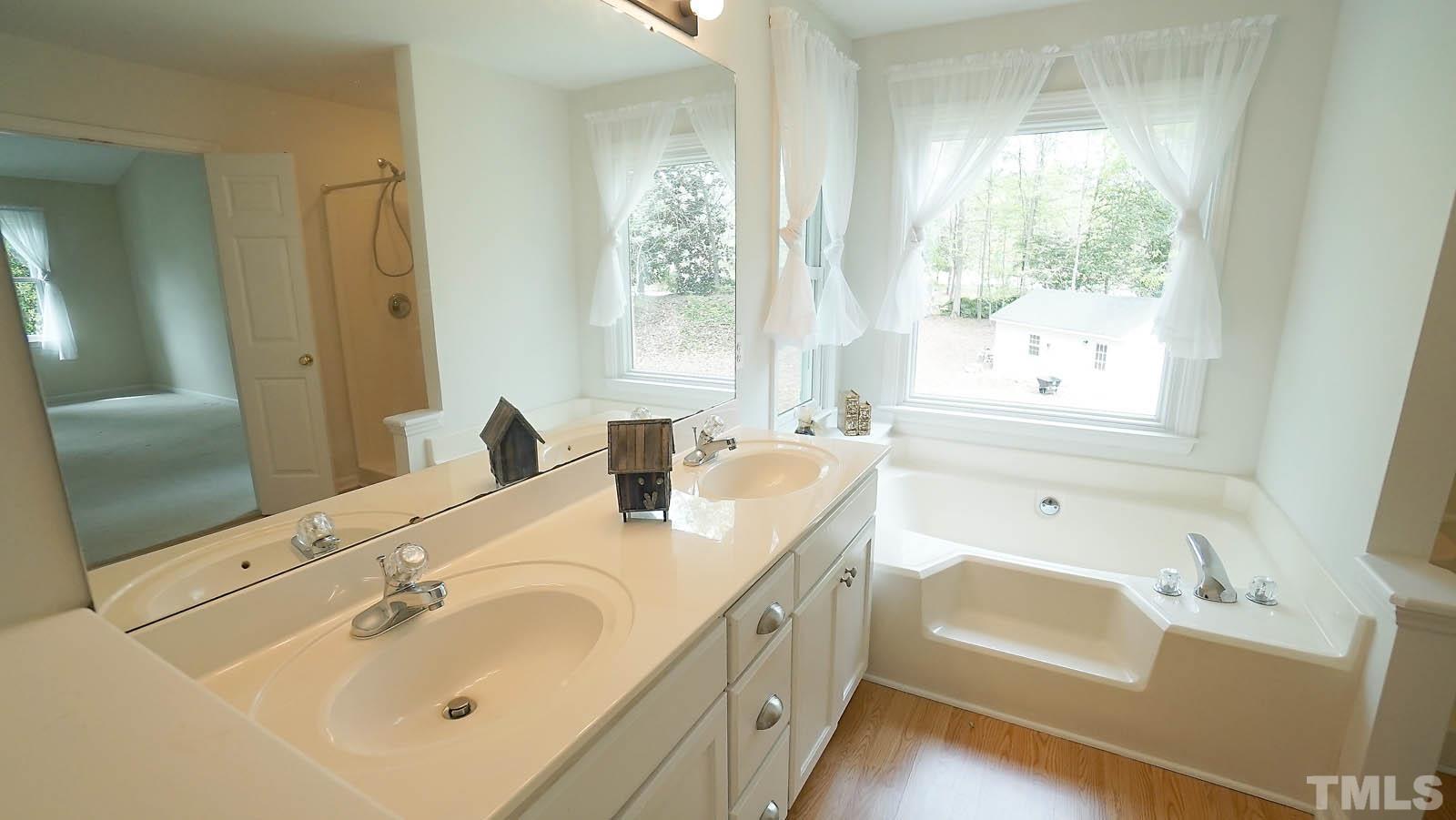 10721 Durant Road Raleigh, NC 27615 - Photo 21 of 37 a bathroom with a tub sink and mirror