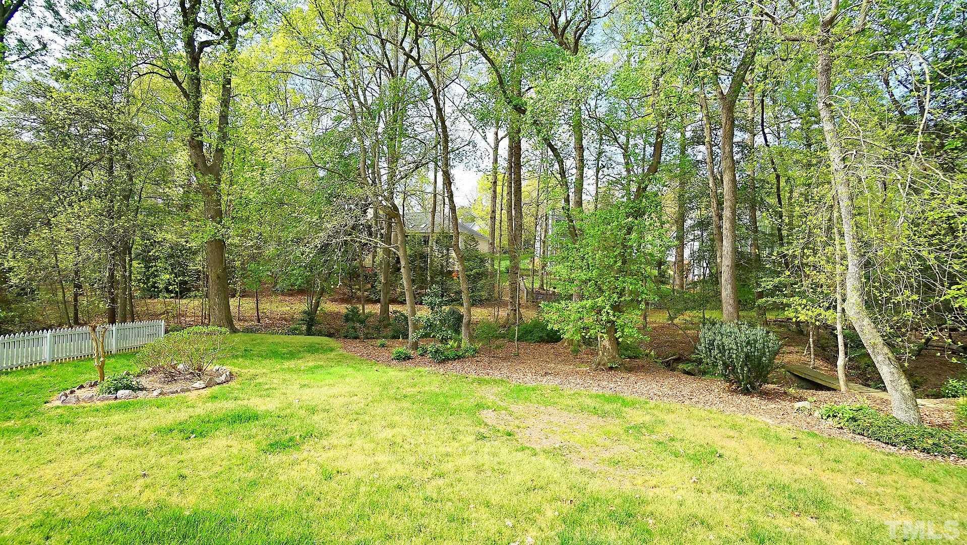 10721 Durant Road Raleigh, NC 27615 - Photo 34 of 37 a backyard of a house with plants and large trees