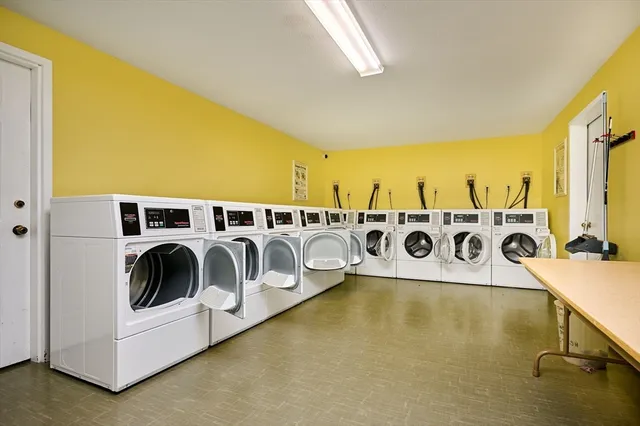a utility room with stainless steel appliances a stove a chimney a sink and cabinets