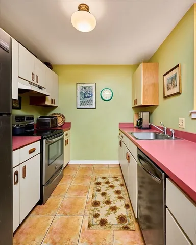 a kitchen with stainless steel appliances a stove a sink and a microwave