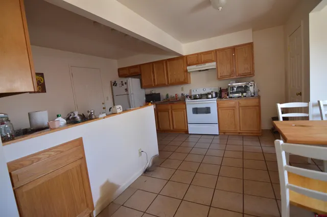 a kitchen with a sink a stove top oven and cabinetry