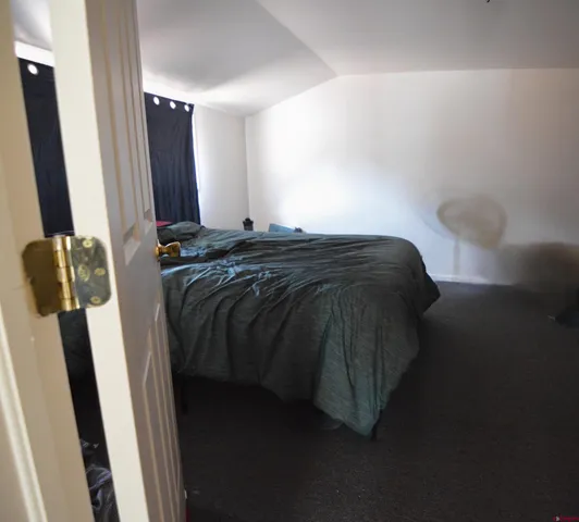 a bed sitting in a bedroom next to a mirror