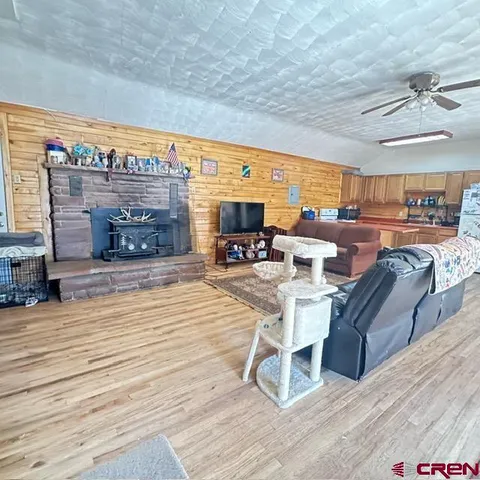 a kitchen with stainless steel appliances granite countertop a refrigerator a stove top oven a sink dishwasher and dining table with wooden floor