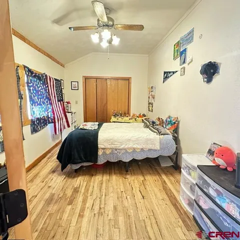 a bedroom with a bed and a wooden floor