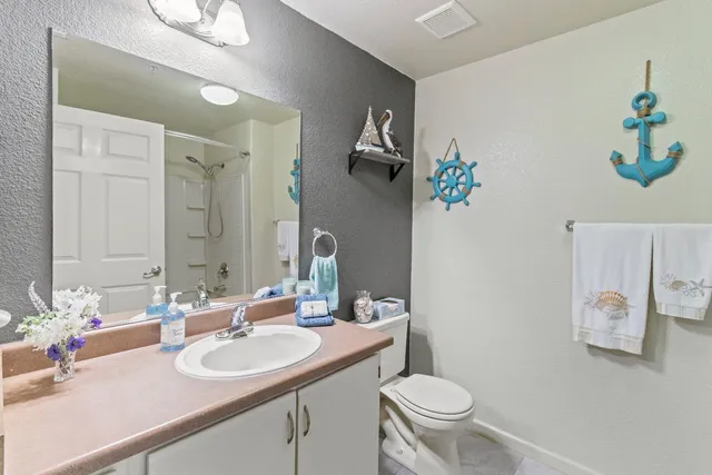 a bathroom with a sink toilet and a mirror