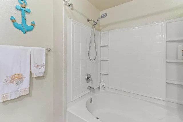 a white bath tub with a shower