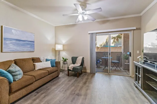 a living room with furniture large window and wooden floor