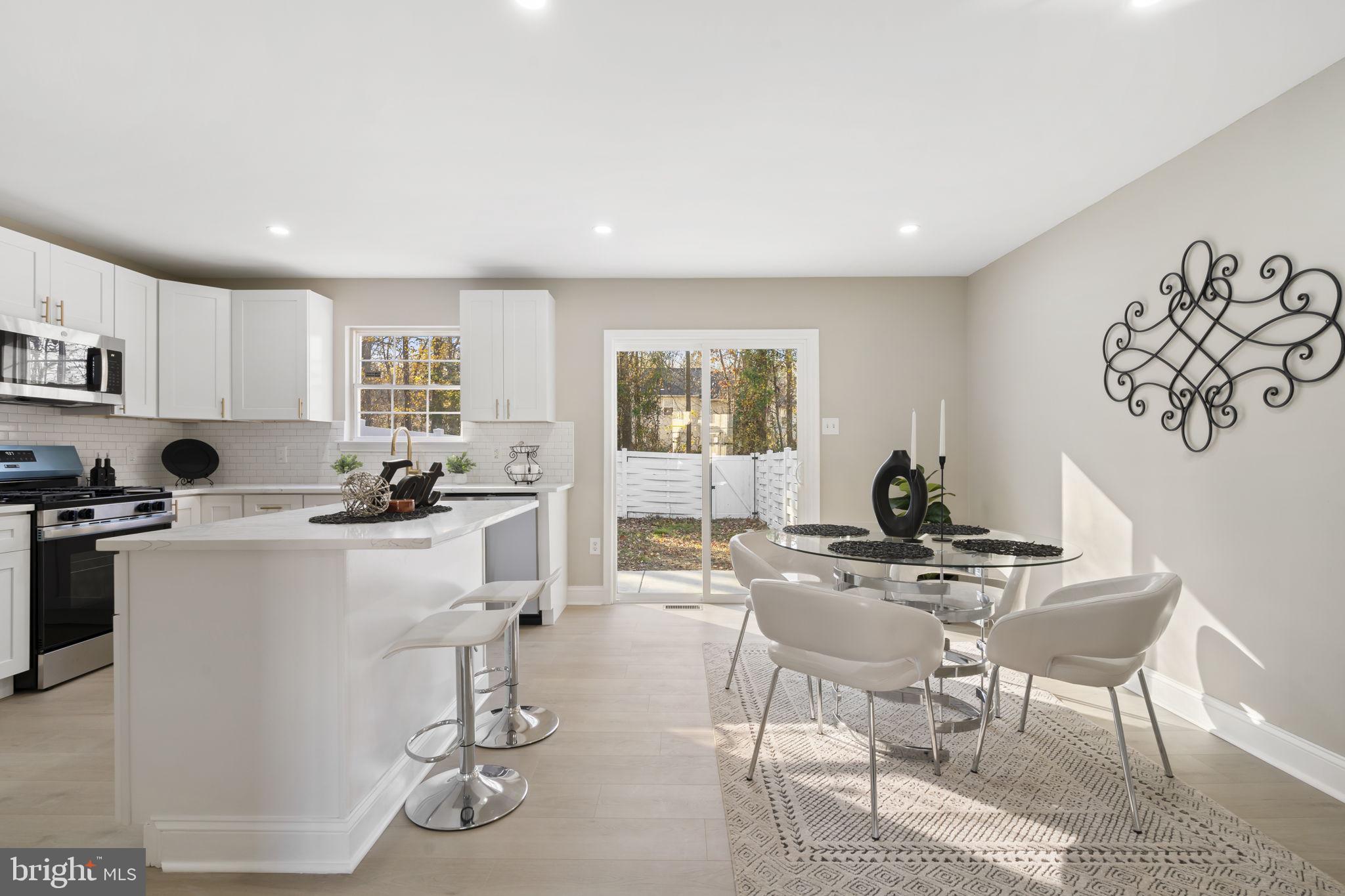 20 Elks Trail New Castle, DE 19720 - Photo 11 of 40 a kitchen with a dining table chairs and white appliances