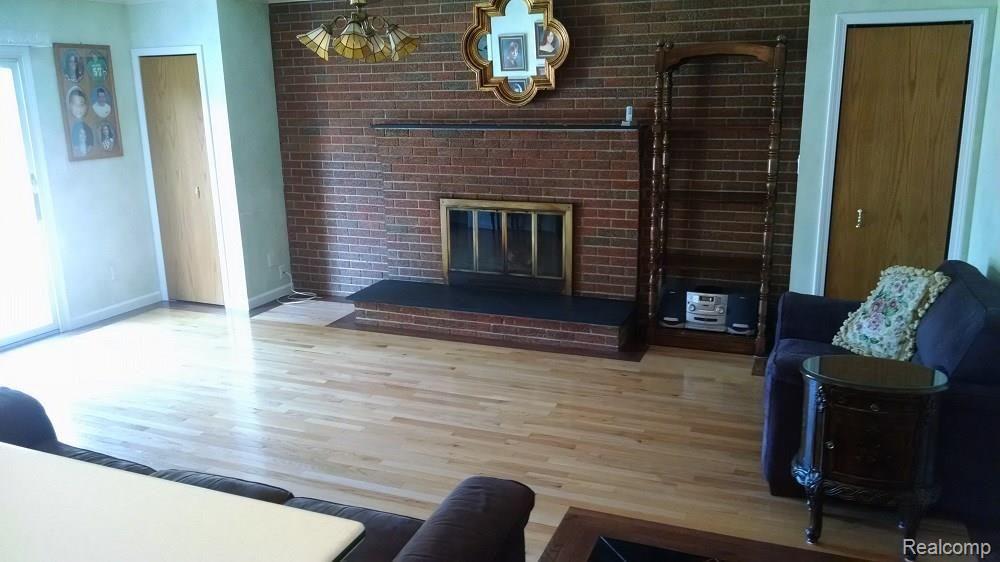 9674 Reeck Road Allen Park, MI 48101 - Photo 14 of 28 FAMILY ROOM VIEWED FROM THE KITCHEN. GAS LOG FIREPLACE AND CUSTOM WOOD FLOORING. DOORWALL TO OUTDOOR PATIO IS ON THE LEFT. THREE PIECE BATH IS ADJACENT TO FAMILY ROOM ON THE LEFT SIDE.