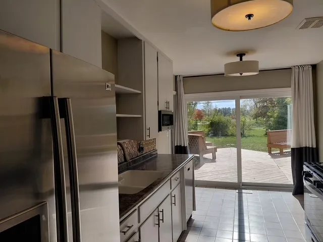 a kitchen with granite countertop a sink stainless steel appliances and cabinets