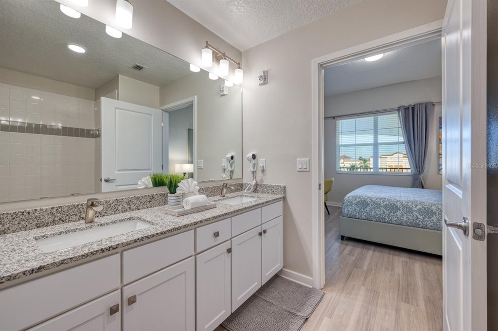 4013 Breakview Drive, Unit A407 Orlando, FL 32819 - Photo 19 of 32 a en suite bathroom with double sink and a large mirror