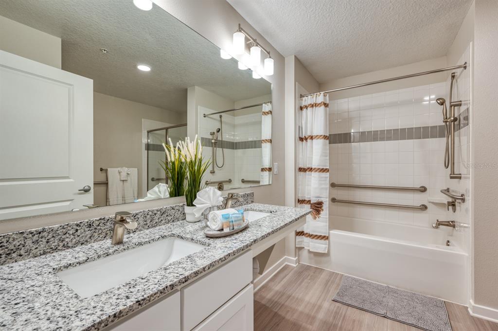 4013 Breakview Drive, Unit A407 Orlando, FL 32819 - Photo 23 of 32 a bathroom with a granite countertop sink mirror toilet and bathtub